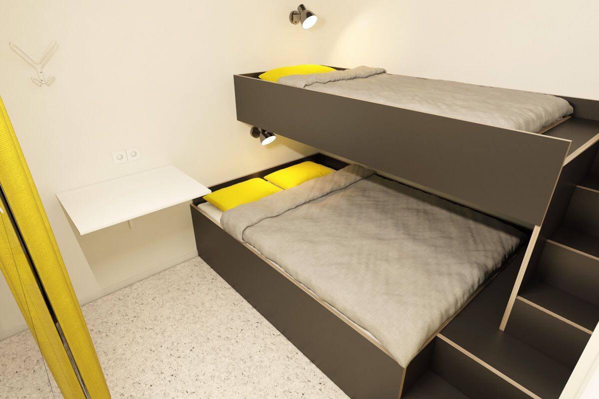 Ein Stockbett mit Schreibtisch darunter, einem kleinen Regal und einer Wandleuchte.