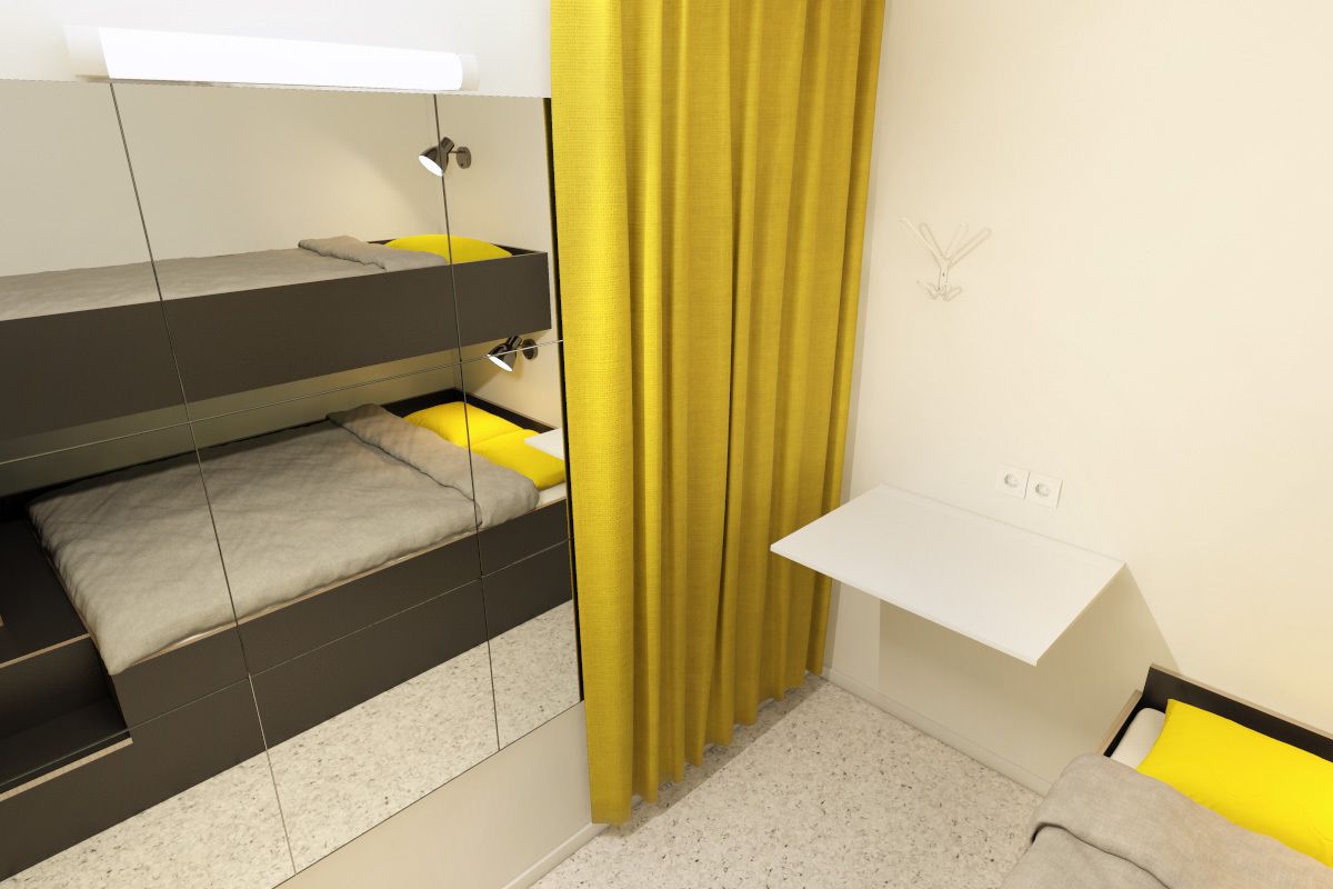 A compact bedroom with a bunk bed, a small desk, and a yellow curtain.