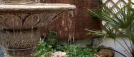 A stone fountain with multiple tiers and water flowing from the top tier.
