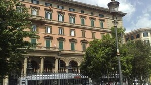 A multi-story building with a classical architectural style, featuring a central entrance with columns and a balcony.