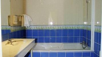 A bathroom with a bathtub, a toilet, and a sink.
