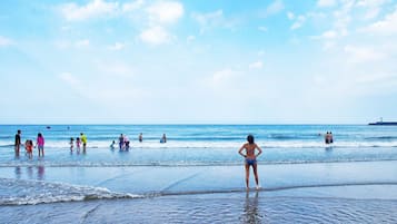 Guests can enjoy a serene beach experience with calm waters and a clear sky.