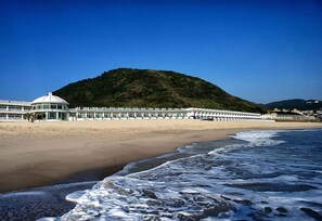 A beach with a dome-shaped building and a row of beachside structures. - White House Beach Hotspring Resort (New Taipei City)