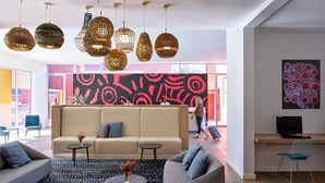 A modern living room with a sofa, coffee table, and decorative lamps. - The Lost Camel (Yulara)