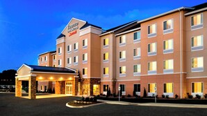 Un hôtel à plusieurs étages doté d’une entrée imposante, d’un hall d’accueil couvert et d’une façade bien éclairée.