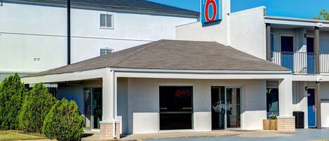 A motel with a '6' sign, a covered entrance, and a parking lot.