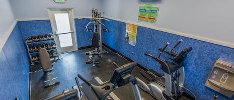 Un gimnasio con cintas de correr, elípticas y pesas sueltas.