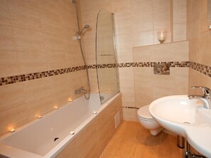 A bathroom with a bathtub, a shower, and a sink.