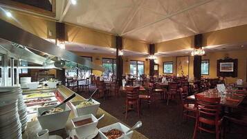 Un buffet avec plusieurs points de service et des tables où les clients peuvent s’asseoir pour manger.