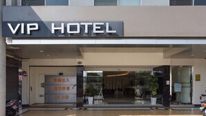 The exterior of a VIP Hotel with a modern facade, a glass entrance, and a sign indicating a 24-hour service area. - Palmer Hotel (Taichung)