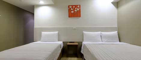 A hotel room with two single beds, a small wooden nightstand, and a red floral artwork on the wall.