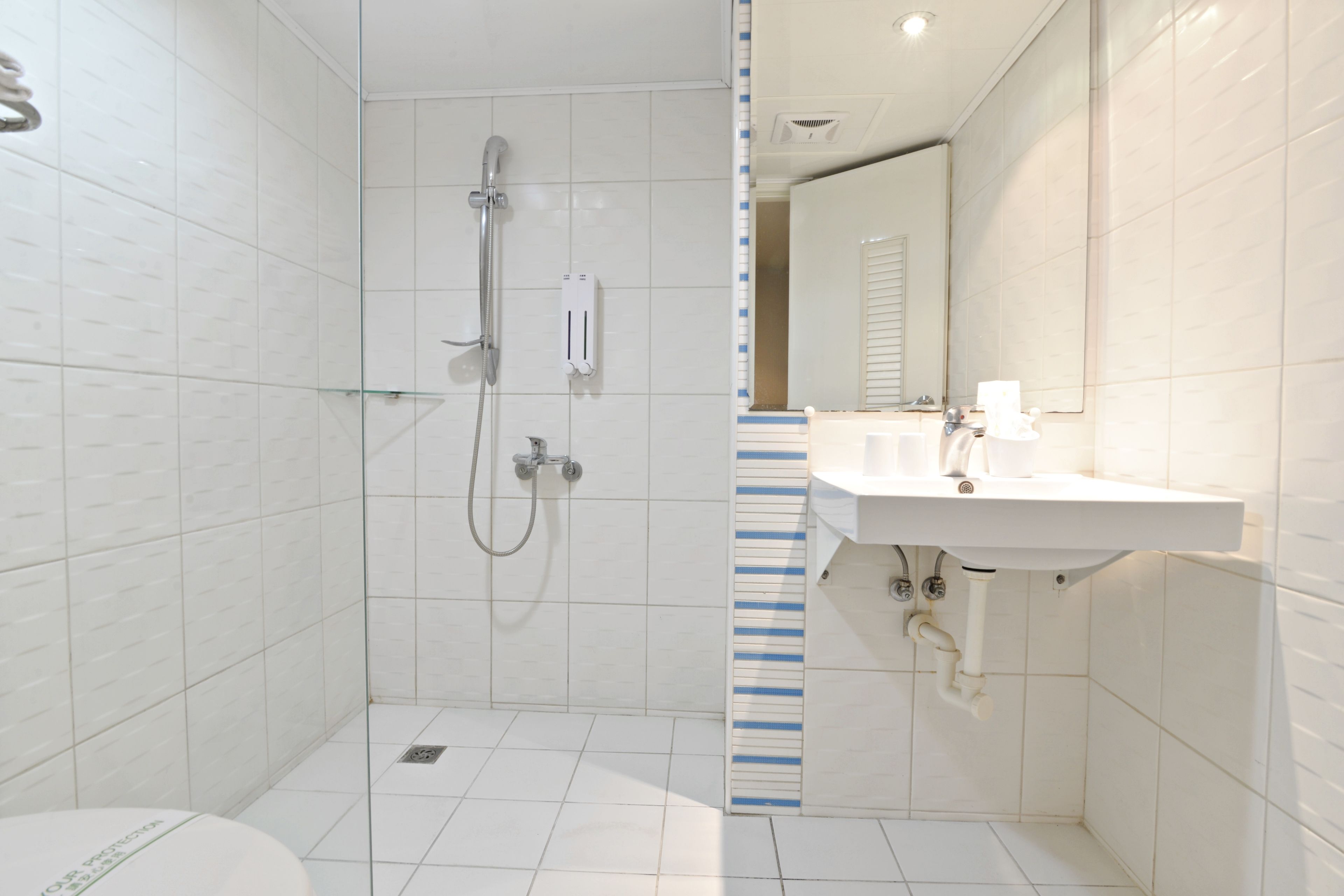 A modern bathroom with a shower, toilet, and sink.