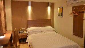 A hotel room with a bed, bedside table, and a wooden headboard. There is a wall-mounted air conditioner and a framed picture on the wall. - Ane Hotel - Xinhong Branch (Chengdu)