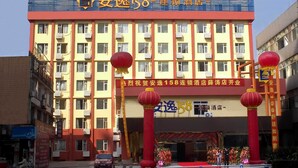 A hotel with a prominent sign reading "安逸158连锁酒店".