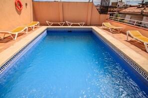 Utomhuspool, parasoller och solstolar