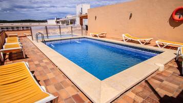 Een buitenzwembad, parasols voor strand/zwembad
