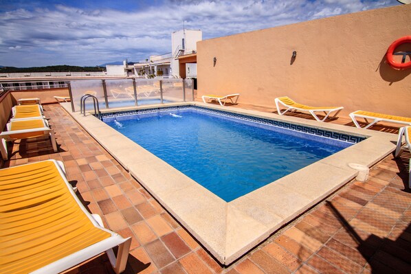 Alberca al aire libre, sombrillas en la alberca y camastros 