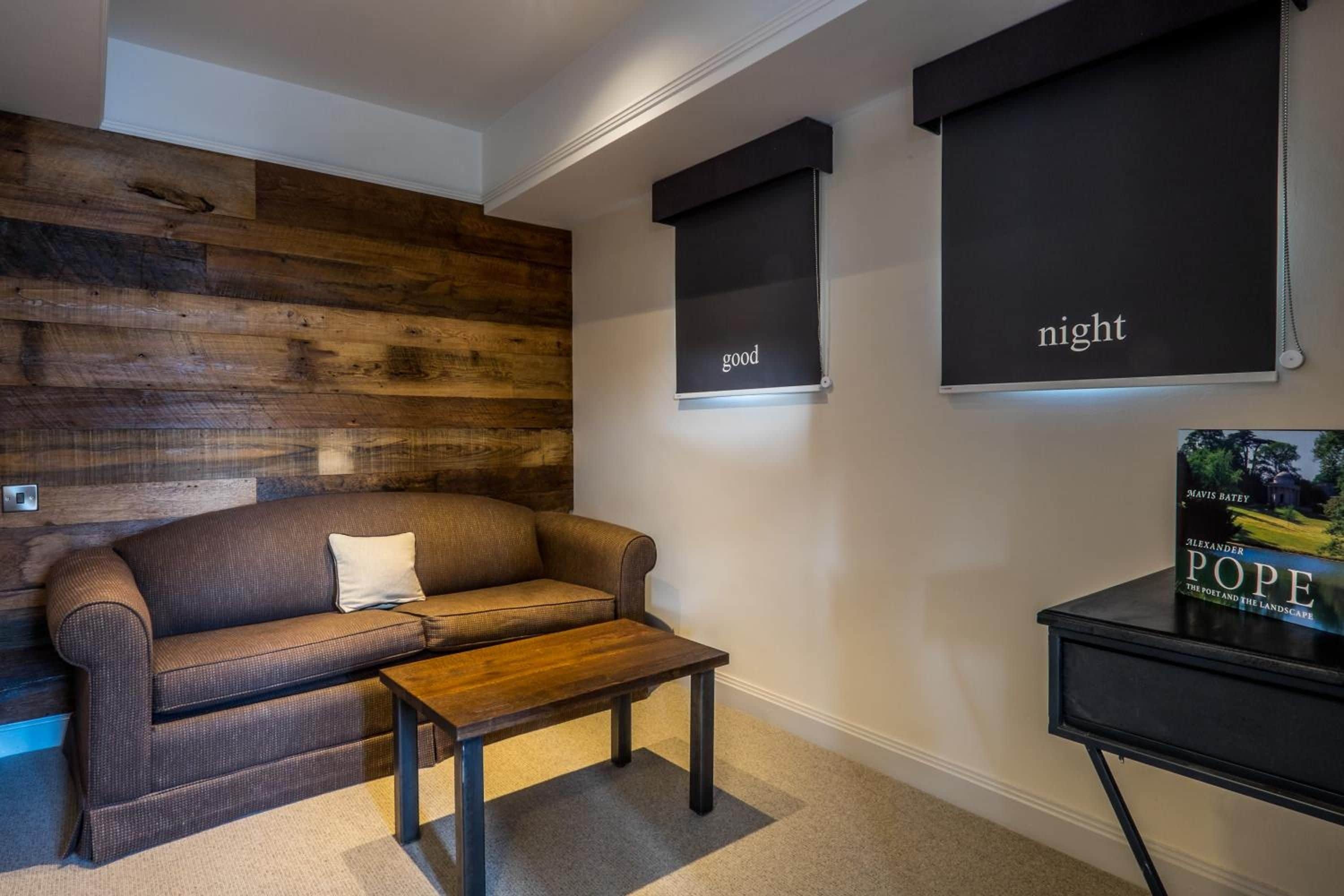 A modern living room with a brown leather sofa, a wooden accent wall, and a small wooden coffee table.