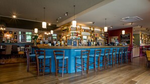 A bar area with a blue counter, wooden chairs, and hanging lights. - Alexander Pope (Twickenham)