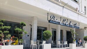 Une boulangerie-café avec une terrasse et une façade en pierre.
