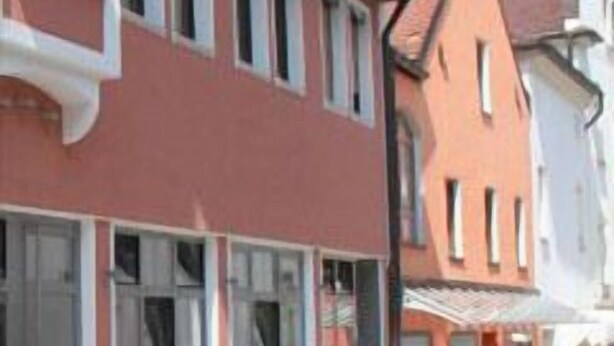 Een rij traditionele, Europese gebouwen met grote ramen en een kinderafgesloten straat.