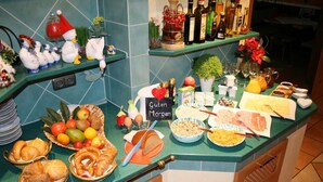 Een ontbijtbuffet met diverse gerechten, waaronder fruit, brood en gebak.