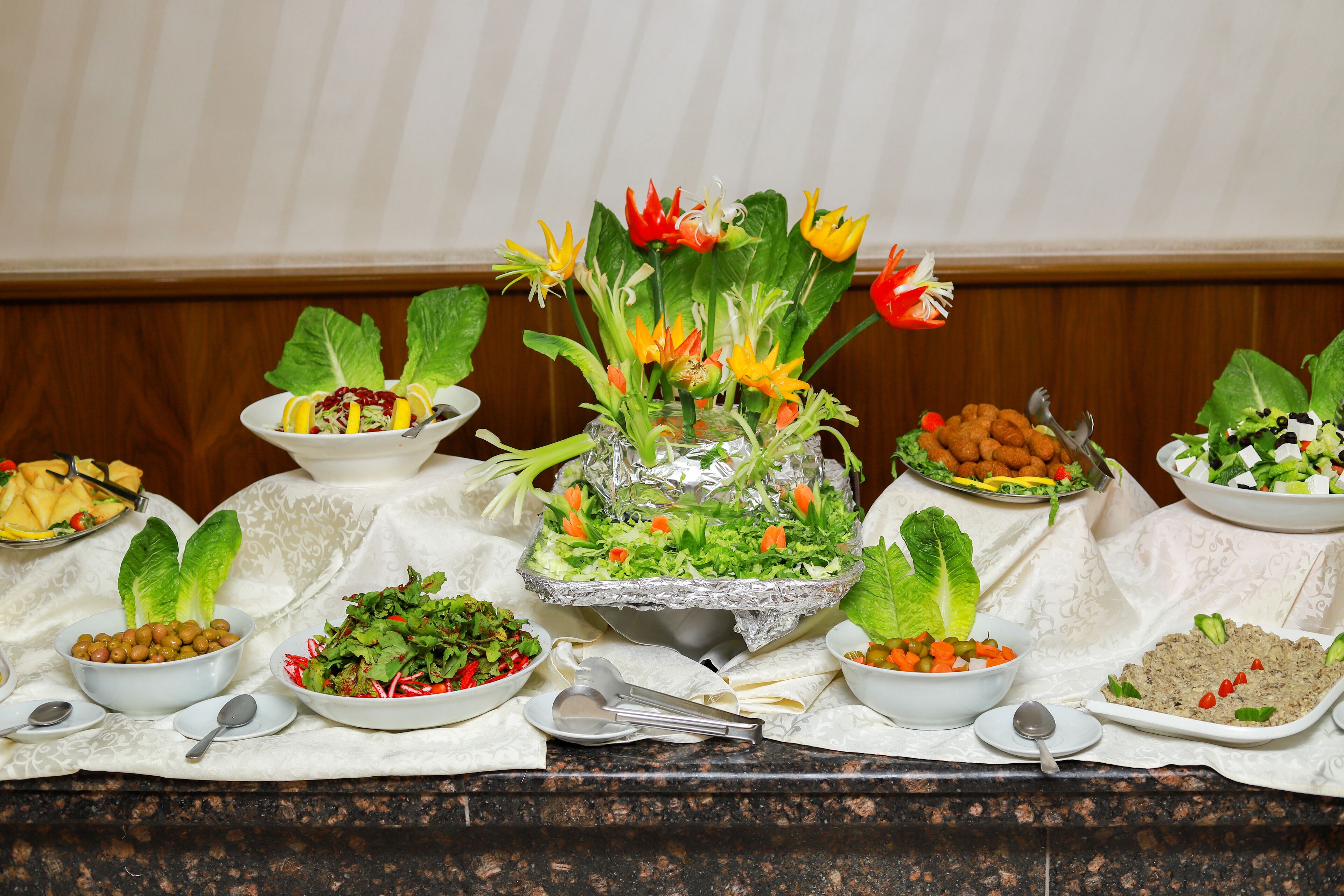 A buffet table with various dishes and a decorative centerpiece.