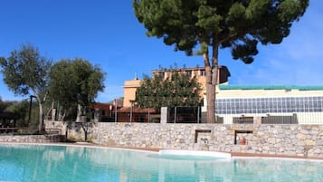 Una piscina al aire libre de temporada, sombrillas
