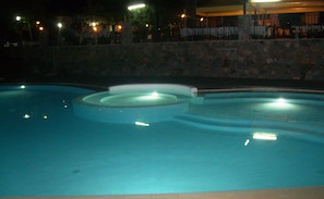 A swimming pool with a stone wall and steps leading into the water. - Park Hotel Cilento (Camerota)