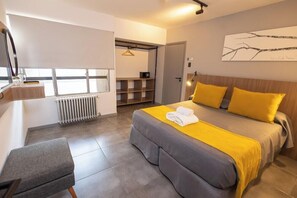 A modern hotel room with a bed, bedside table, and a view of the hallway. - Hotel King'S Bariloche (San Carlos de Bariloche)