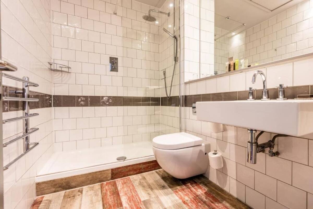 Moderni kylpyhuone, jossa on suihku, wc ja pesuallas.