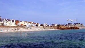 Un pueblo costero con casas frente a la playa y una playa de arena.