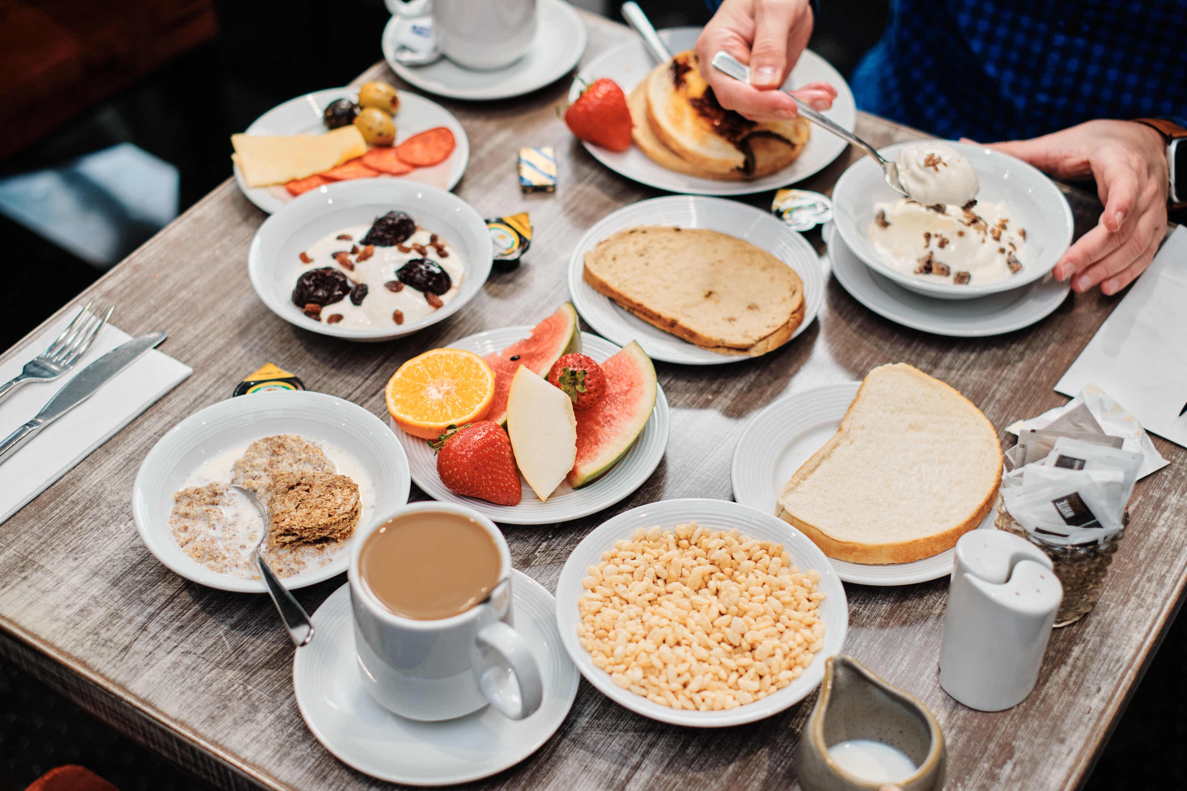 Una mesa de desayuno con diferentes alimentos y una taza de café.