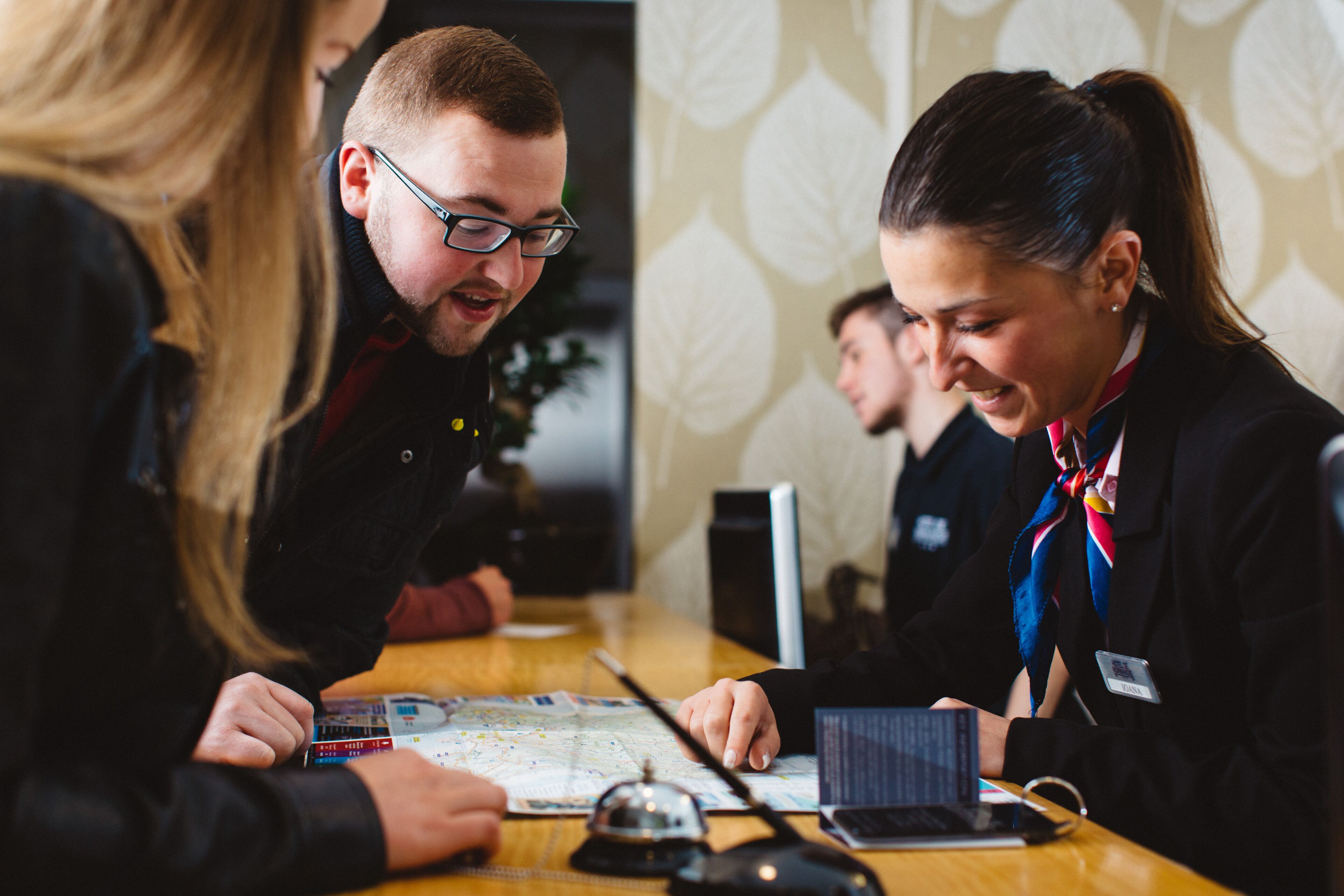 A group of people at a table with a map and a laptop, suggesting a planning or discussion session.