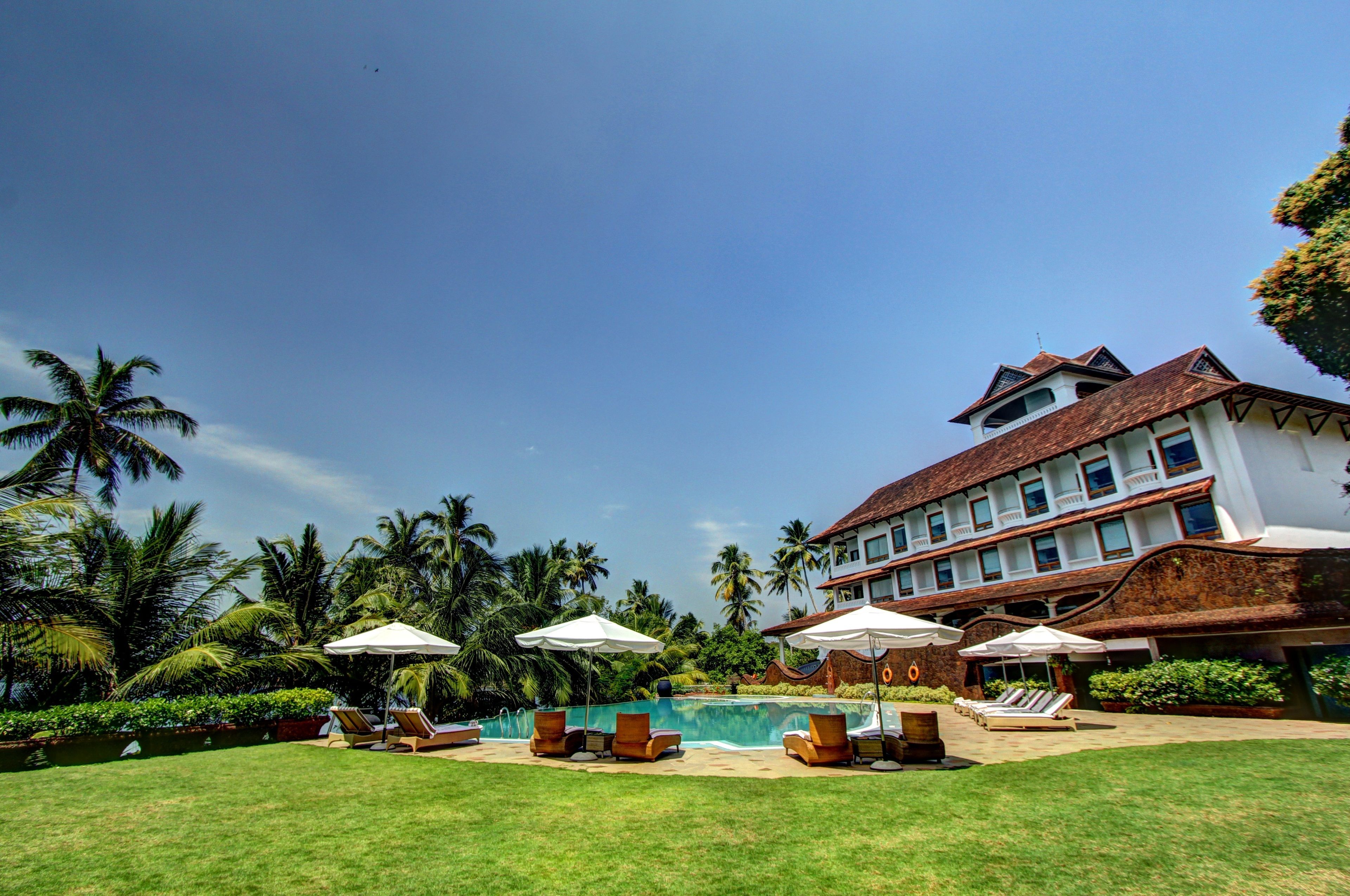 Un resort con piscina, sillas de descanso y palmeras.