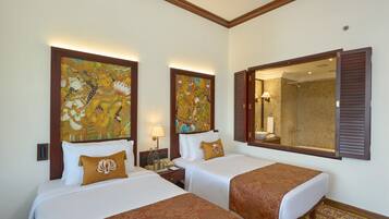 A hotel room with two beds, a large mirror, and artwork on the walls.