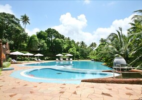 Una piscina al aire libre, sillones reclinables de piscina