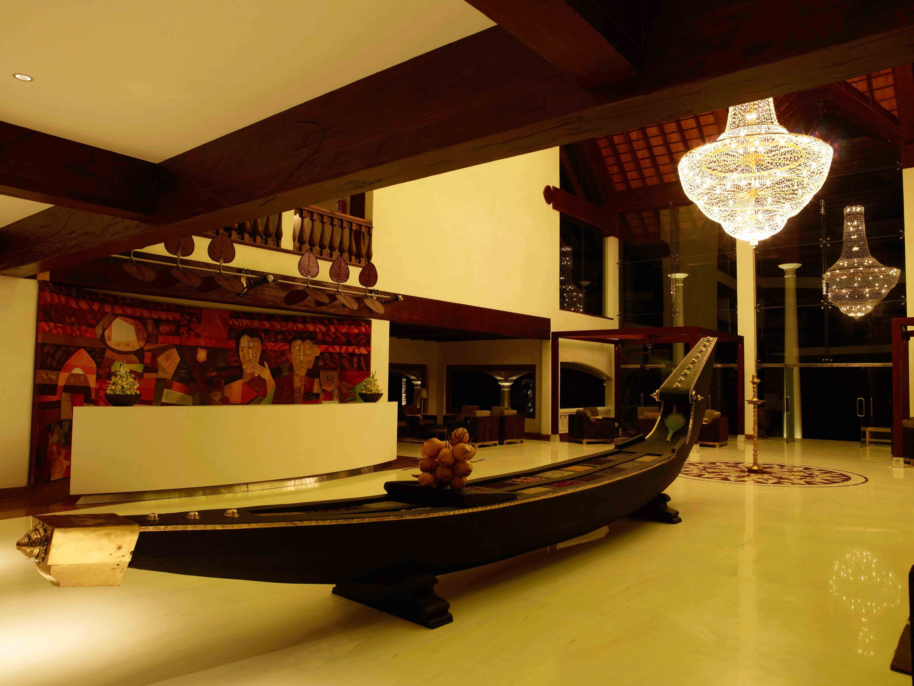 A spacious lobby with a large, ornate boat centerpiece, a grand chandelier, and a modern staircase.