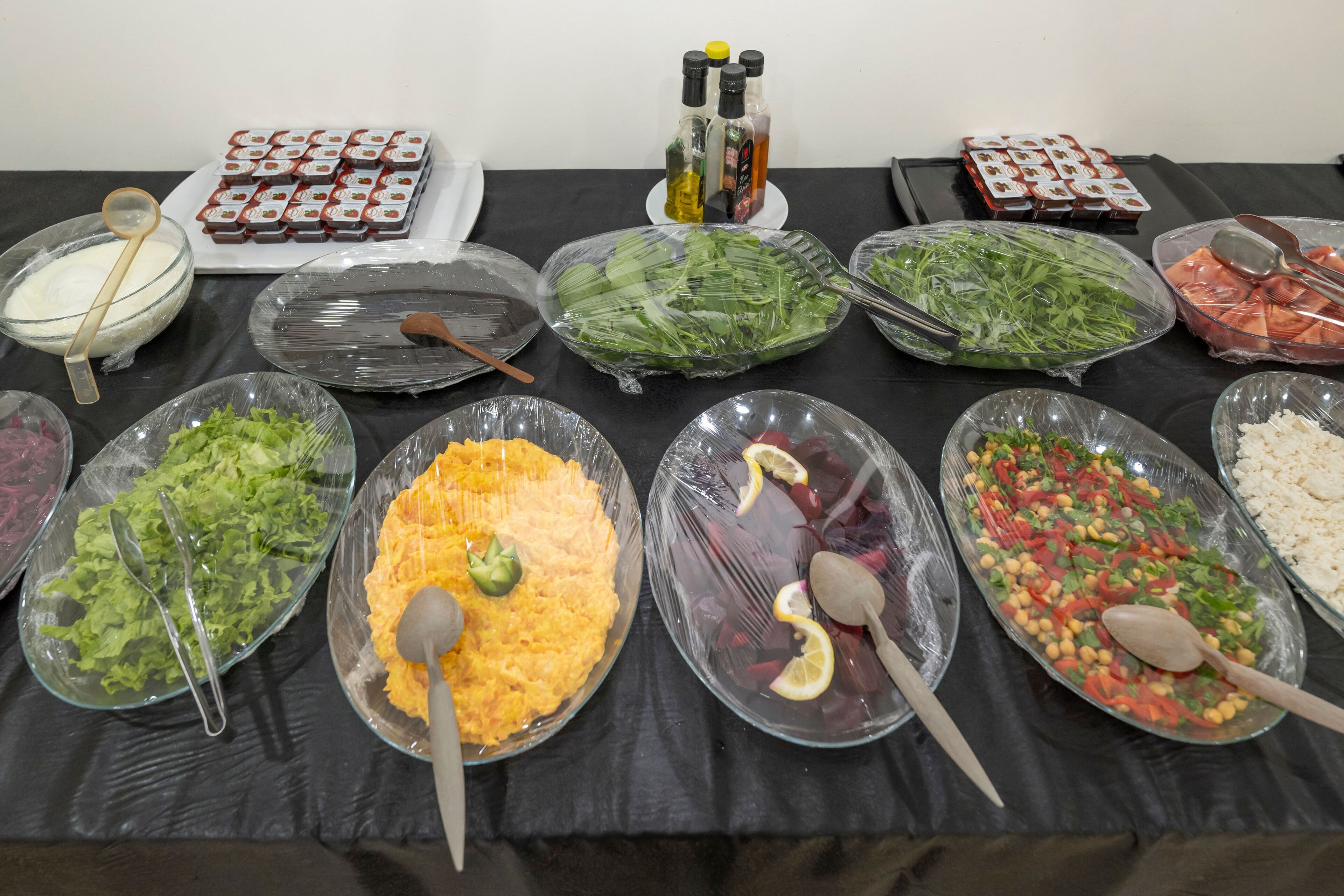 A buffet table with various food items and condiments.