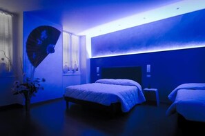 A modern hotel room with a large bed, a bedside table, and a wall-mounted fan. - Via Palazzo Sanremo (Sanremo)