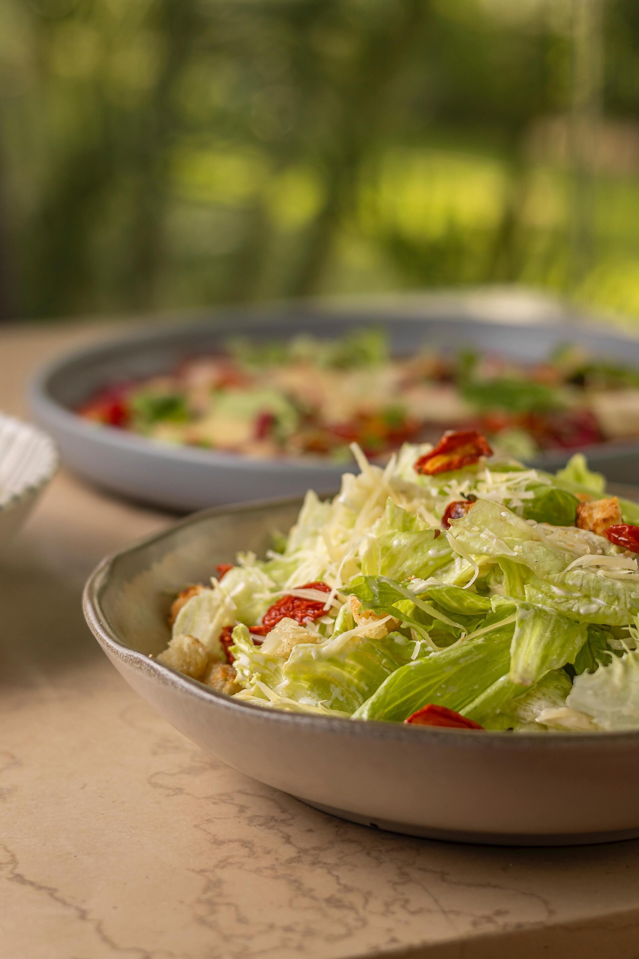 A bowl of salad with lettuce and croutons.