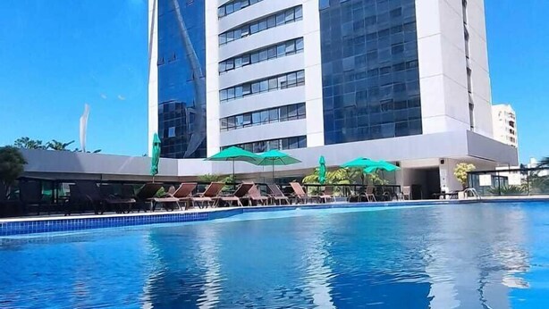 Ein modernes Hotel mit Pool vor der Fassade.