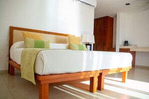 Suite junior, 1 cama de matrimonio grande, frente al mar | Minibar, caja fuerte, mobiliario individual y cortinas opacas