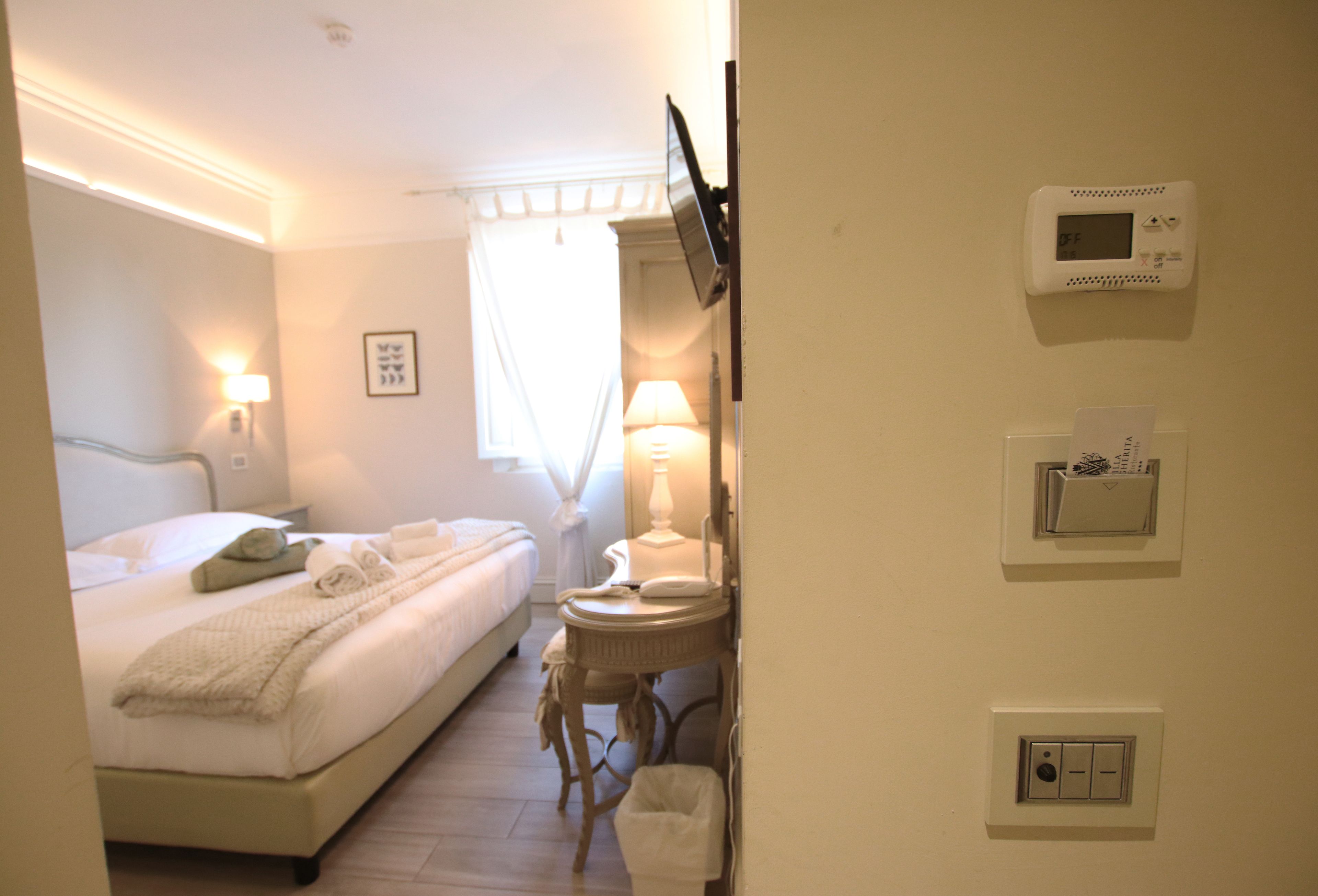 Une chambre d’hôtel avec un lit, une lampe de chevet et une petite table avec une lampe.