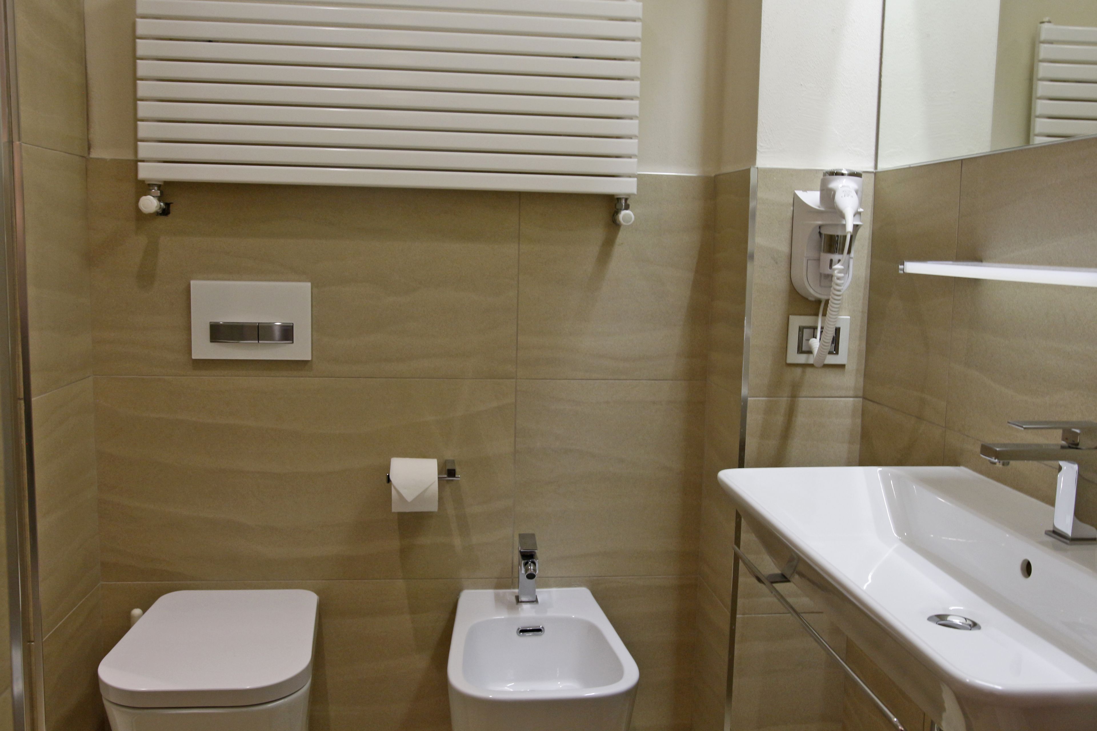 A modern bathroom with a toilet, bidet, and sink.