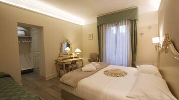 Habitación de hotel con una cama grande, un tocador con espejo, una silla y un vestidor.