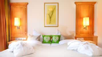 Ein Hotelzimmer mit einem großen Bett, zwei Nachttischen, einem gerahmten Kunstwerk an der Wand und einem Fenster mit Vorhängen.