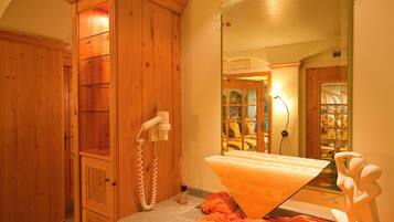 Un baño con muebles de madera, un espejo grande y una bañera.
