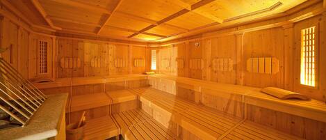 A sauna with wooden benches and a sloped ceiling.