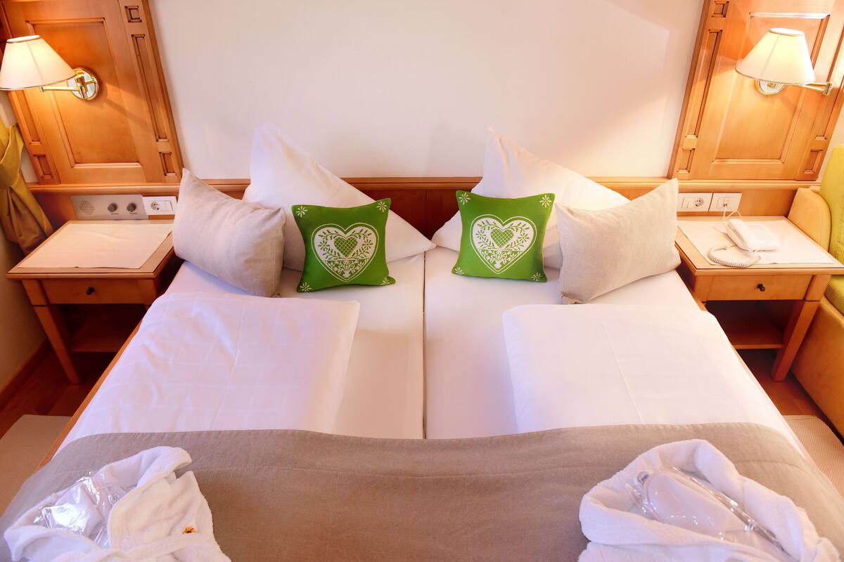 A hotel room with a double bed, two nightstands, a lamp, and a telephone.